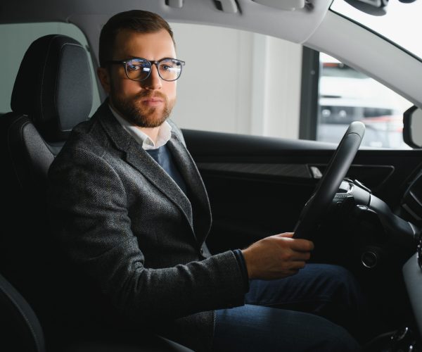 Handsome male taxi driver in car